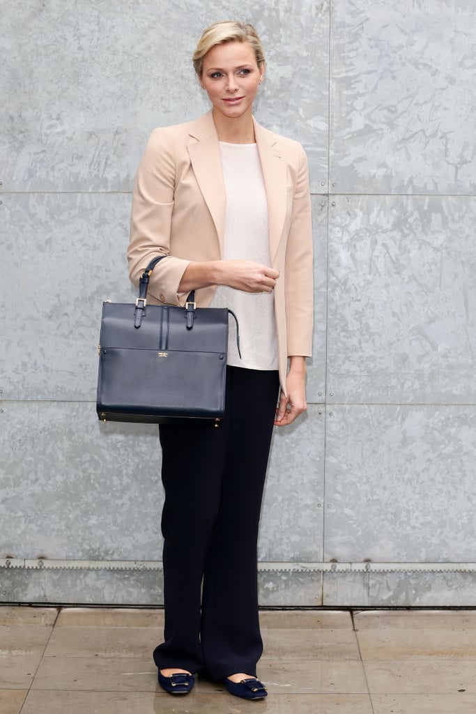 In February 2013, Princess Charlene wore black trousers with a white tee, blush blazer, and flats to the Giorgio Armani show.