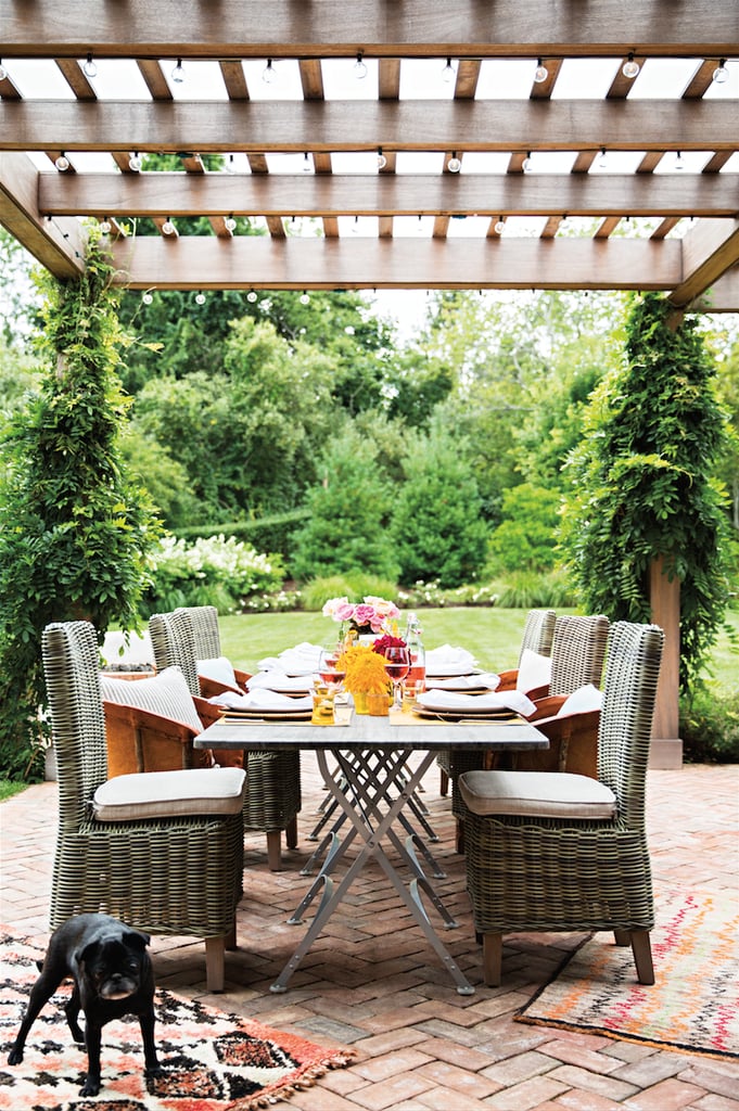 Bistro lights are woven tightly through the patio's pergola to cast a soft glow from the beams. Instead of a large outdoor rug, smaller versions lay diagonally for a less contrived look. How cute is her Pug, Fionula?
For even more inspiring photos, take the full tour of Katie's home at domino!
