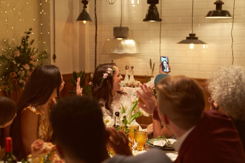 Two married girls having a wedding dinner party with some of their close  friends and another friend makes a video call