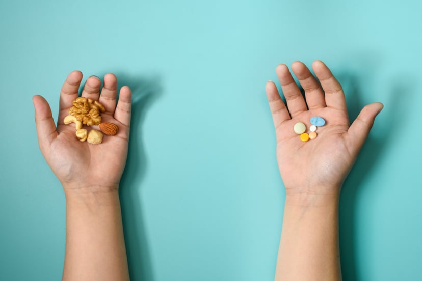 little kid hands holding kids vitamins and nuts; do kids need vitamins?