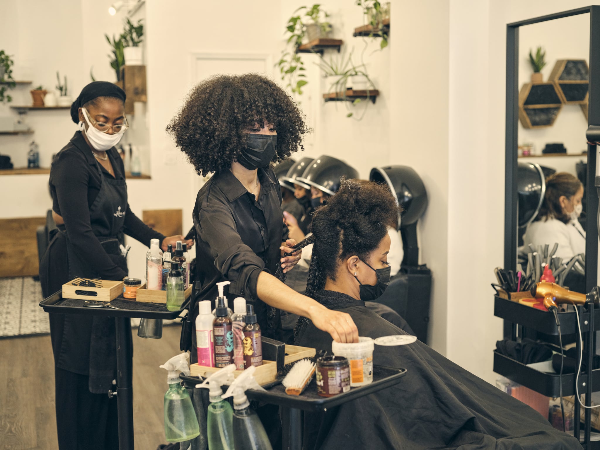 Woman styles a customer's natural curly hair at the salon