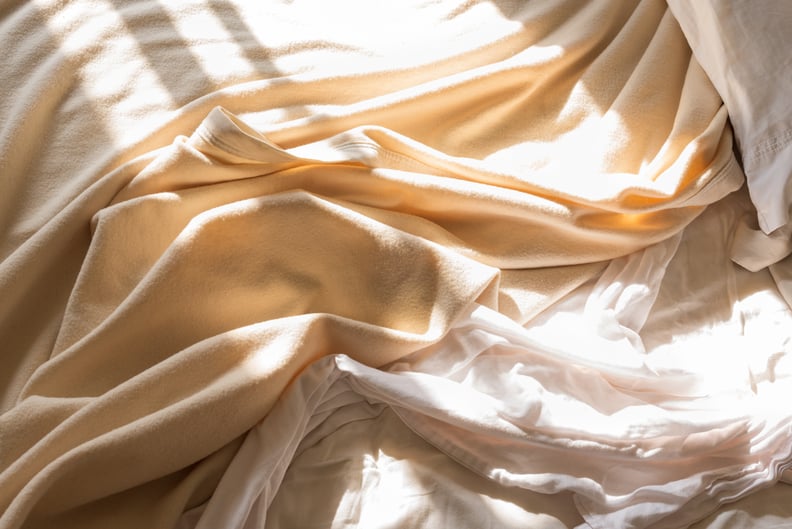 unmade bed in morning sunlight