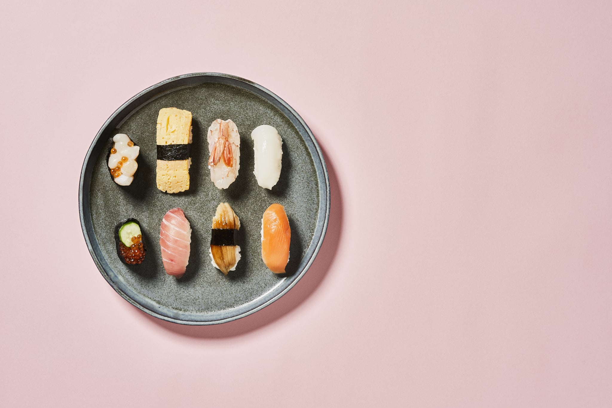 A plate of sushi against a baby pink background. The ike jime fish-handling technique is a sustainable way forward.