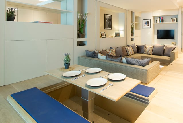 The kitchen table is not part of the floor: it's nestled beneath the floor. Two panels that cover the table open to reveal padded seats.