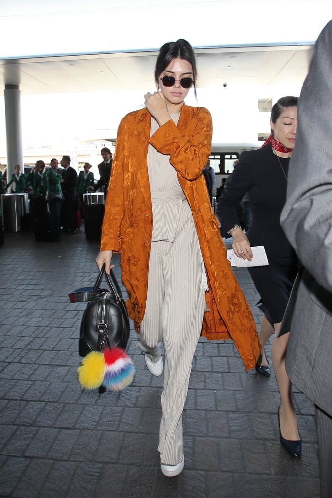 When it comes to jet-setting, Kendall Jenner knows to pack the chicest top layer there is: a bright-colored duster!