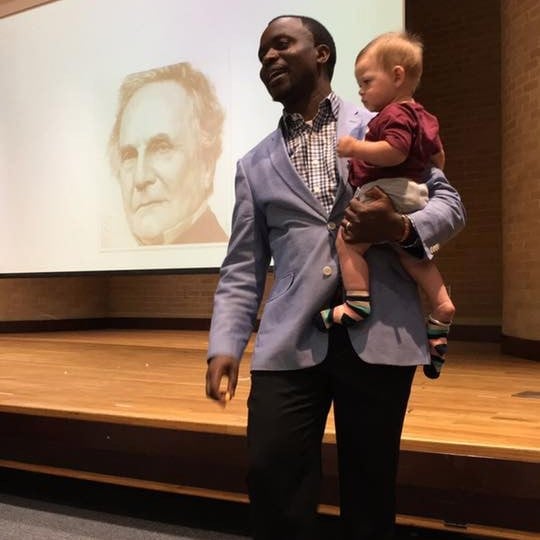 Professor Holds Toddler While Teaching Class