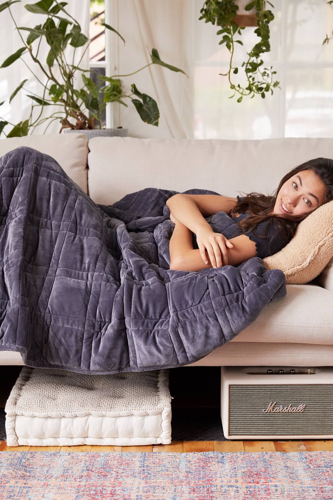 A weighted blanket may be just what every stressed-out college student needs this Winter. They're thought to ease anxiety by hugging your body, which helps reduce cortisol levels, while triggering the release of the feel-good hormones oxytocin and serotonin. Oh, and they're super cozy — but priced at a couple hundred dollars or more, they're not exactly budget-friendly. At least not until now.
Enter the Plush 15 lb Weighted Blanket ($139) from Urban Outfitters. This beautiful blanket is made with a soft, dark gray fleece that's sure to match any dorm or apartment, no matter the color scheme. It evenly distributes 15 pounds onto your body — a good starting point, since weighted blankets should be about 10 percent of your body weight. And it's even machine-washable!
If that sounds like everything your holiday dreams are made of, add it to your own list — then settle in for a warm, restful Winter.