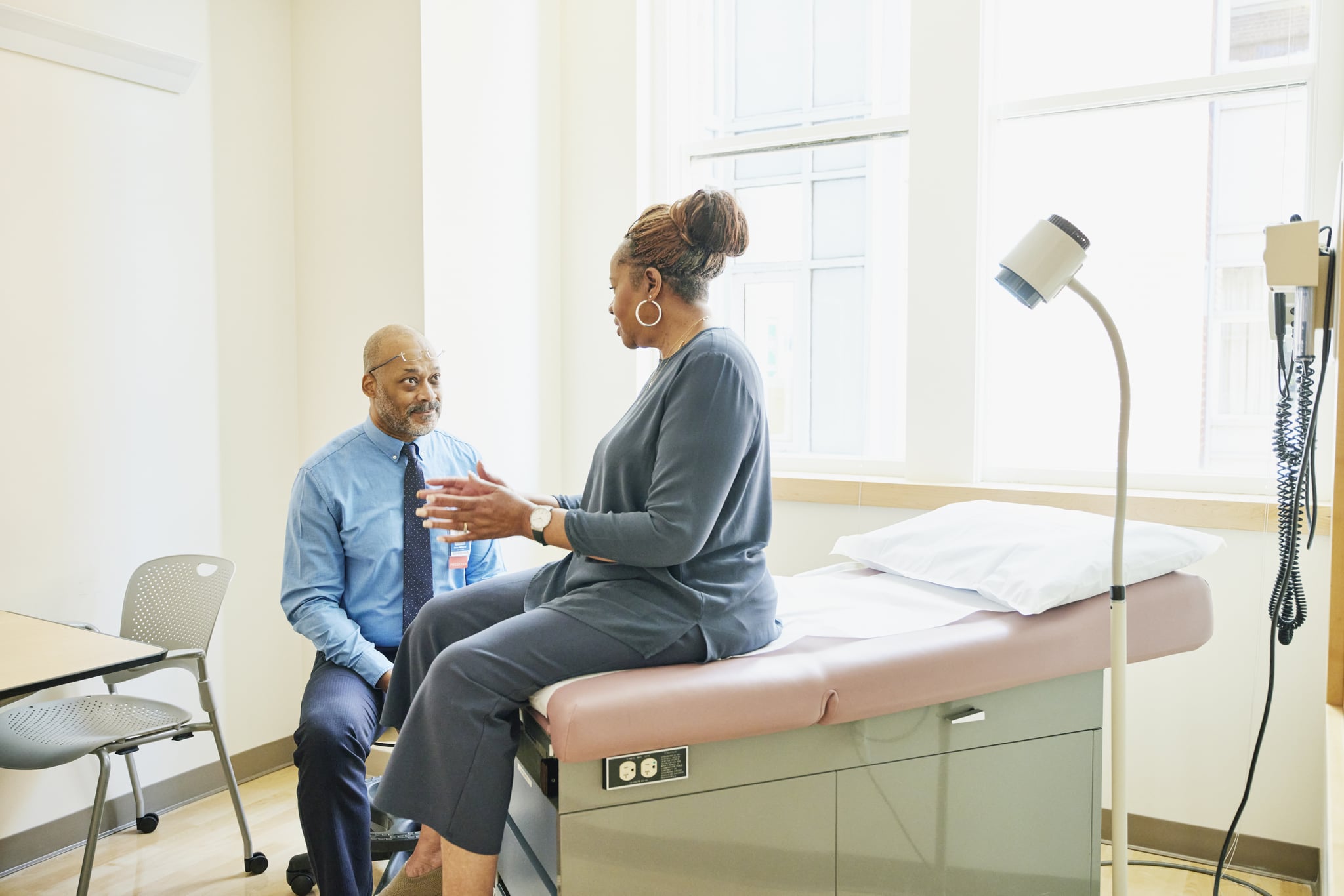 Shot of senior woman in discussion with doctor during check up in exam room in doctors office.