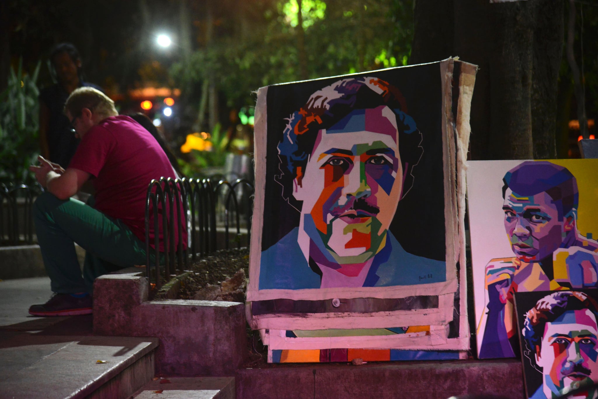 Paintings depicting late Colombian drug lord Pablo Escobar are on display at Lleras Park in  Medellin, Antioquia department, Colombia on July 21, 2016.The paintings are made by Colombian artist Wilson Rojas, who sells them by the equivalent of 120-130 dollars each. / AFP / RAUL ARBOLEDA        (Photo credit should read RAUL ARBOLEDA/AFP via Getty Images)