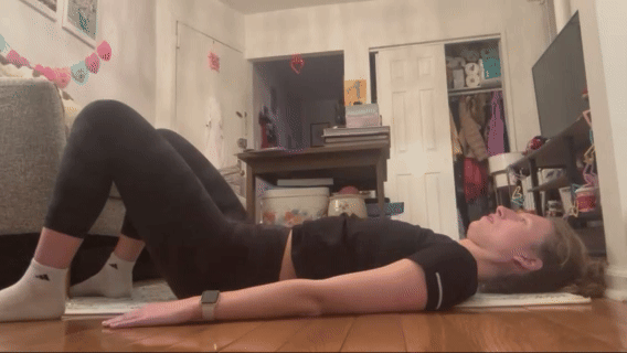 Courtney Campbell doing bridge exercises in her home.