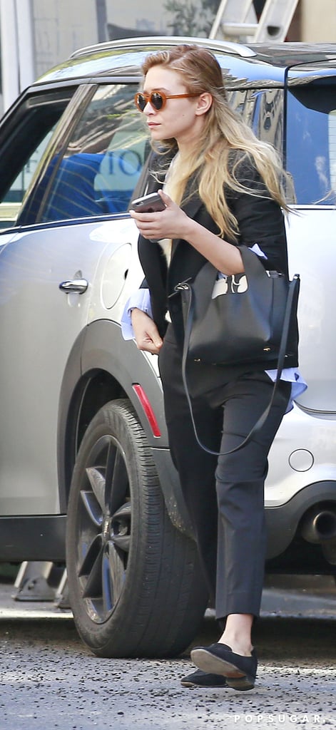 Ashley topped her button-down with a caped jacket and finished her look with classic black loafers.