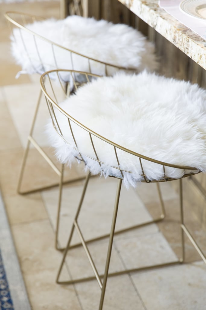The adjacent eat-in kitchen bar becomes super stylish with the addition of hip metal frame benches sheathed in cozy sheepskin.