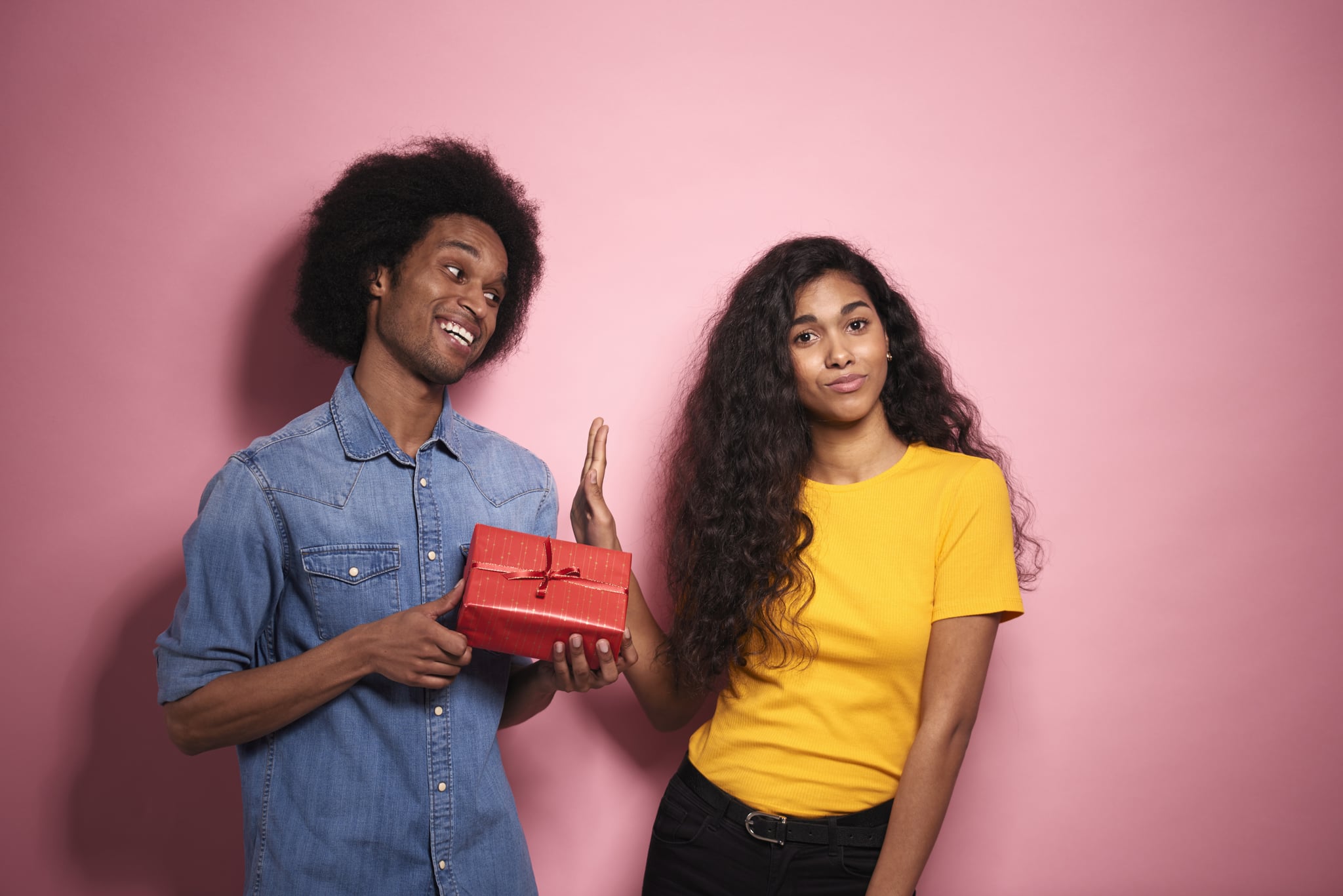 Man giving a gift to a woman in studio shot.