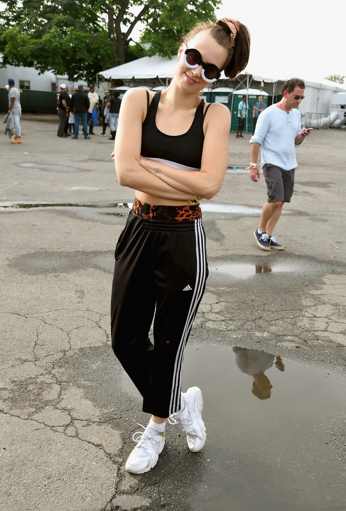 Performer Mo embraced athleticwear for the day, donning Adidas track pants and a sports bra while out and about at the festival.