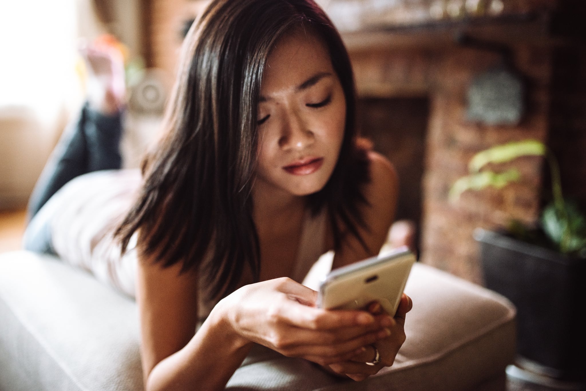 chinese woman text messageing on the phone at home