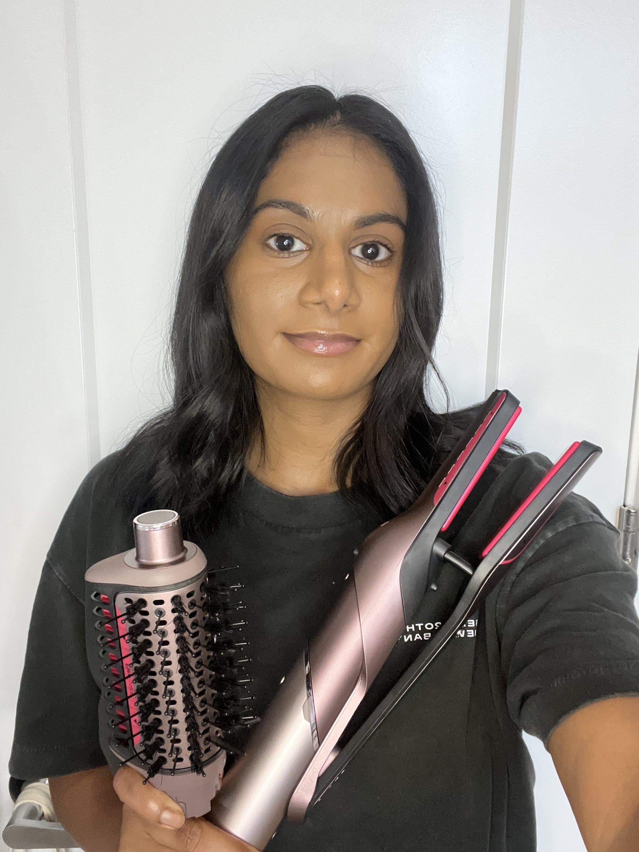 Woman holding the Shark FlexFusion Straight, Air & Ceramic System, including the Wet-or-Dry Air Straightener and the Wet-or-Dry Fusion Brush.