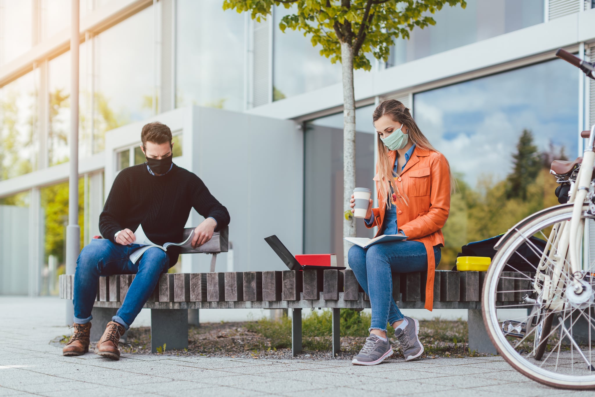 Two college students learning while keeping social distance on campus