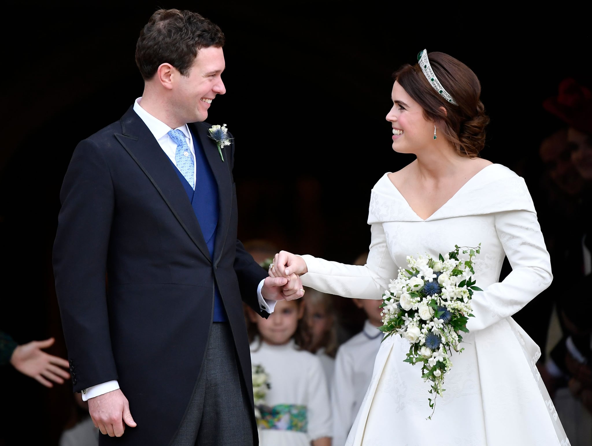 Britain's Princess Eugenie of York (R) and her husband Jack Brooksbank emerge from the West Door of St George's Chapel, Windsor Castle, in Windsor, on October 12, 2018 after their wedding ceremony. (Photo by TOBY MELVILLE / POOL / AFP)        (Photo credit should read TOBY MELVILLE/AFP/Getty Images)