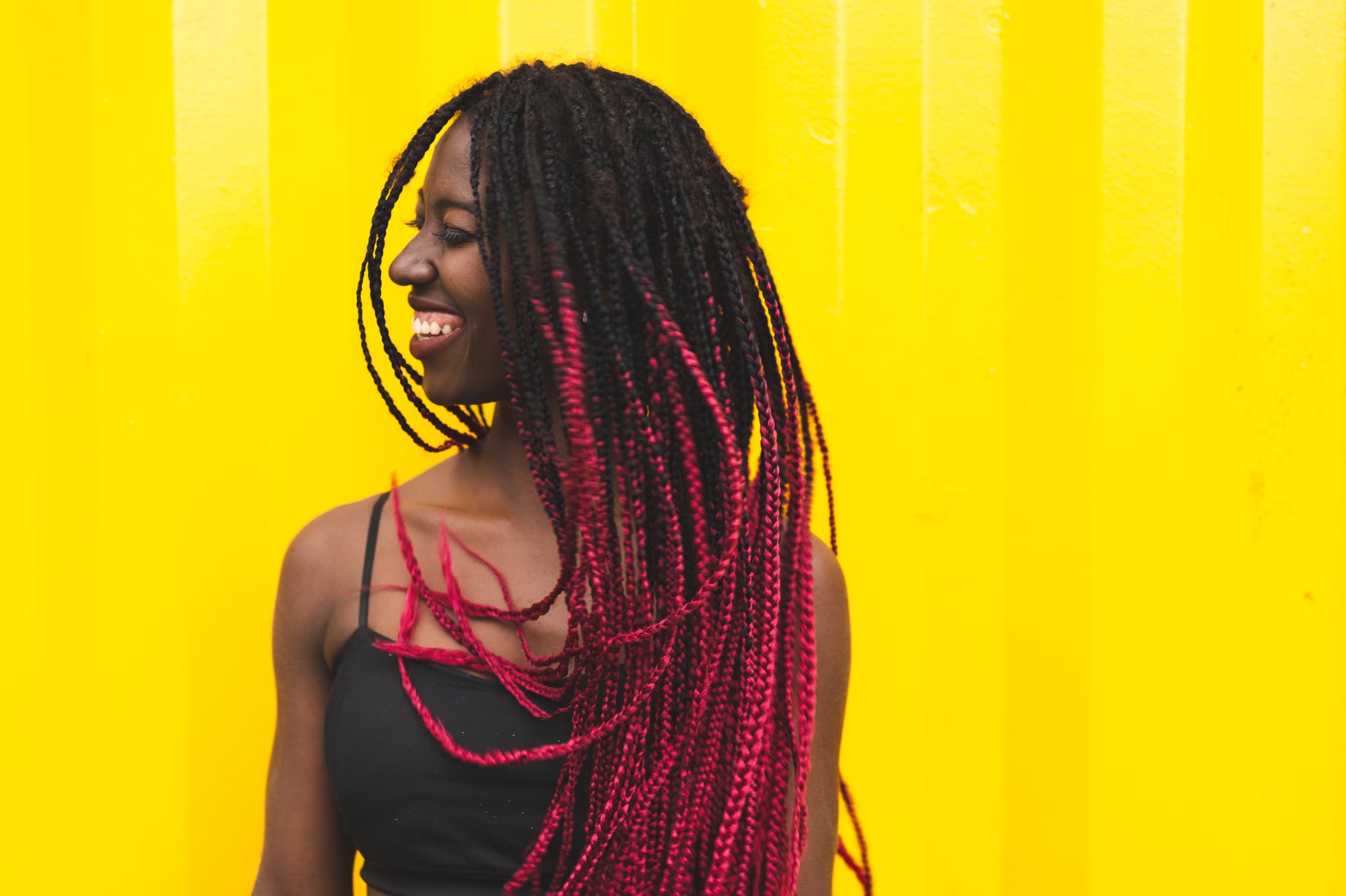 Stylish afro girl with red braided hair dancing and smiling. Brazilian women