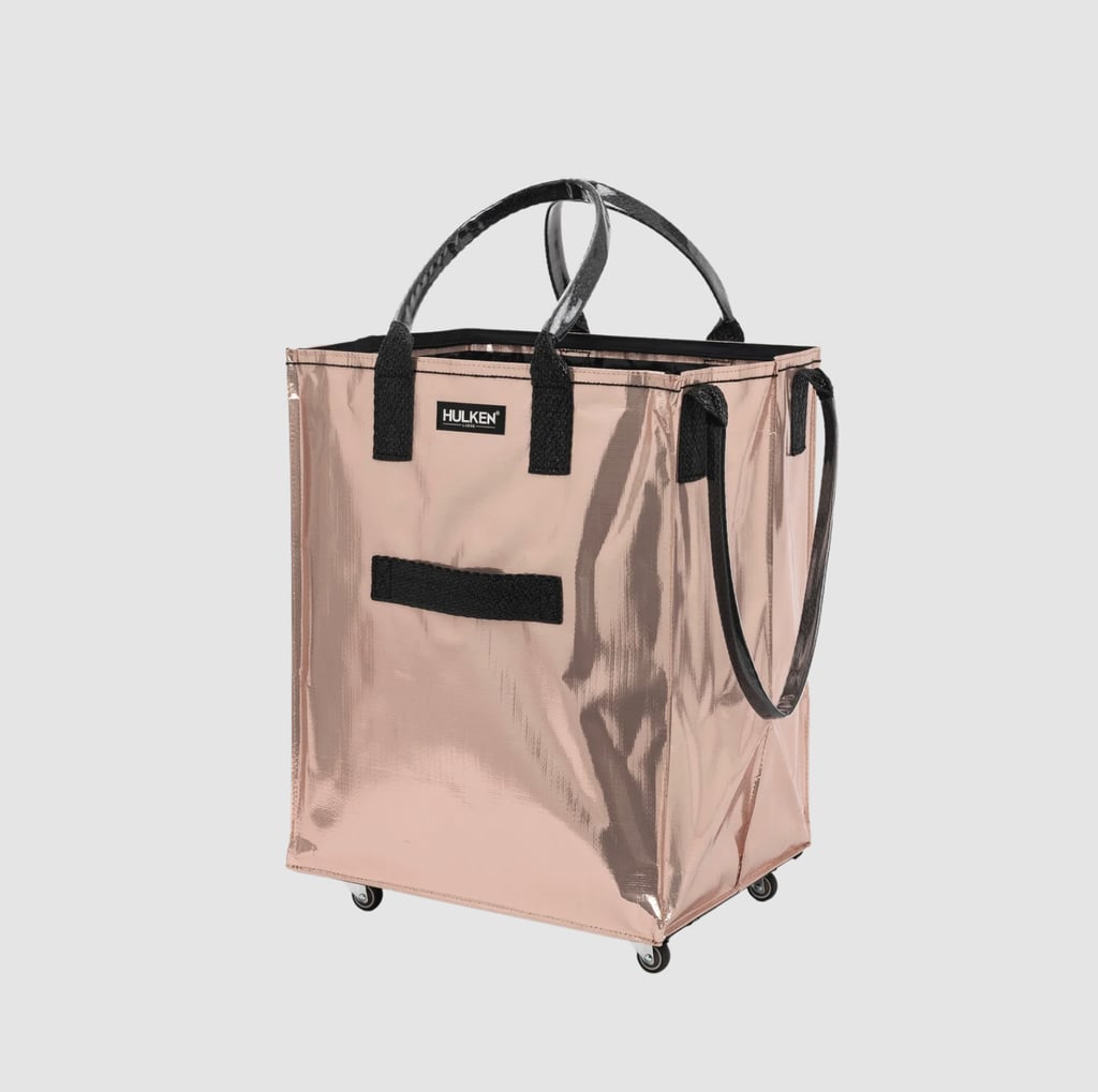 Hulken Signature Rolling Tote Bag ($125)
As a professional Aunt, one thing I always seem to be doing is schlepping. Schlepping groceries, soccer equipment, beach toys, and the list goes on. This viral rolling tote bag is a godsend; I can pile everything in and roll around to spare my shoulders and back from the pain of lugging a huge load. I also invested in the Hulken Tidy & Chill Insert Set ($58) for two inserts to keep everything organized. It doesn't get more convenient than this.
Plus, they all come in a chic rose gold color that makes schlepping feel, dare I say it, stylish (other colors include silver, midnight blue, and standard black. And to add even more fashionable flair, I added two charms from their collection with design darling Susan Alexandra to celebrate "the city we schlep in": Hulken x Susan Alexandra Schlep-mates Coffee Cup Charm ($55) and Hulken x Susan Alexandra Schlep-mates Coffee Bagel Charm ($59). I smile every time I look at them.