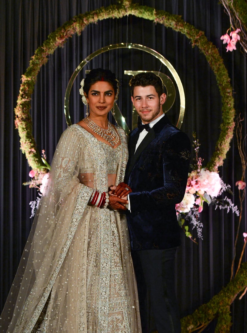 Indian Bollywood actress Priyanka Chopra (L) and US musician Nick Jonas, who were recently married, pose for a photograph during a reception in New Delhi on December 4, 2018. - Bollywood actress Priyanka Chopra and American singer Nick Jonas hosted an ext