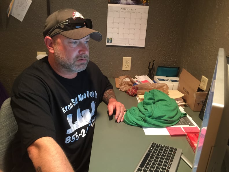 Tugg Massa, 42, checks the call log for Akron Say No To Dope's 24/7 helpline from his organization's thrift store and boutique in Akron, Ohio on Aug. 14. (Photo by Stephanie Haney)