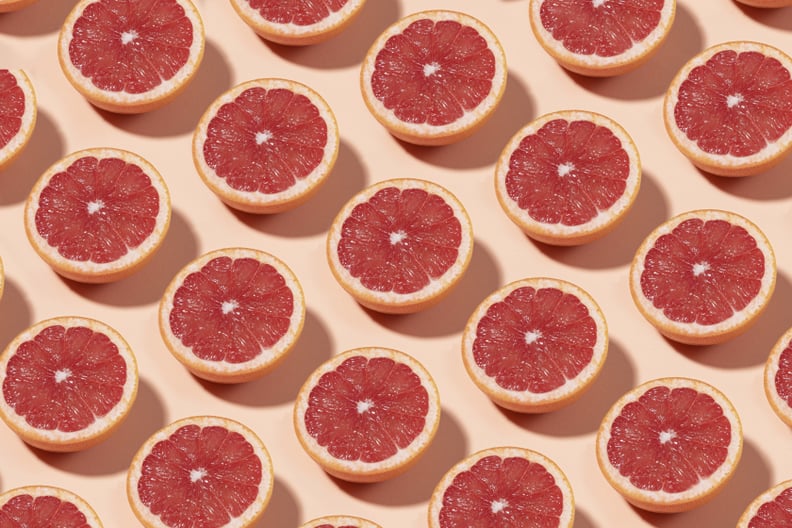 Fruit pattern with half slices of grapefruit on pastel background