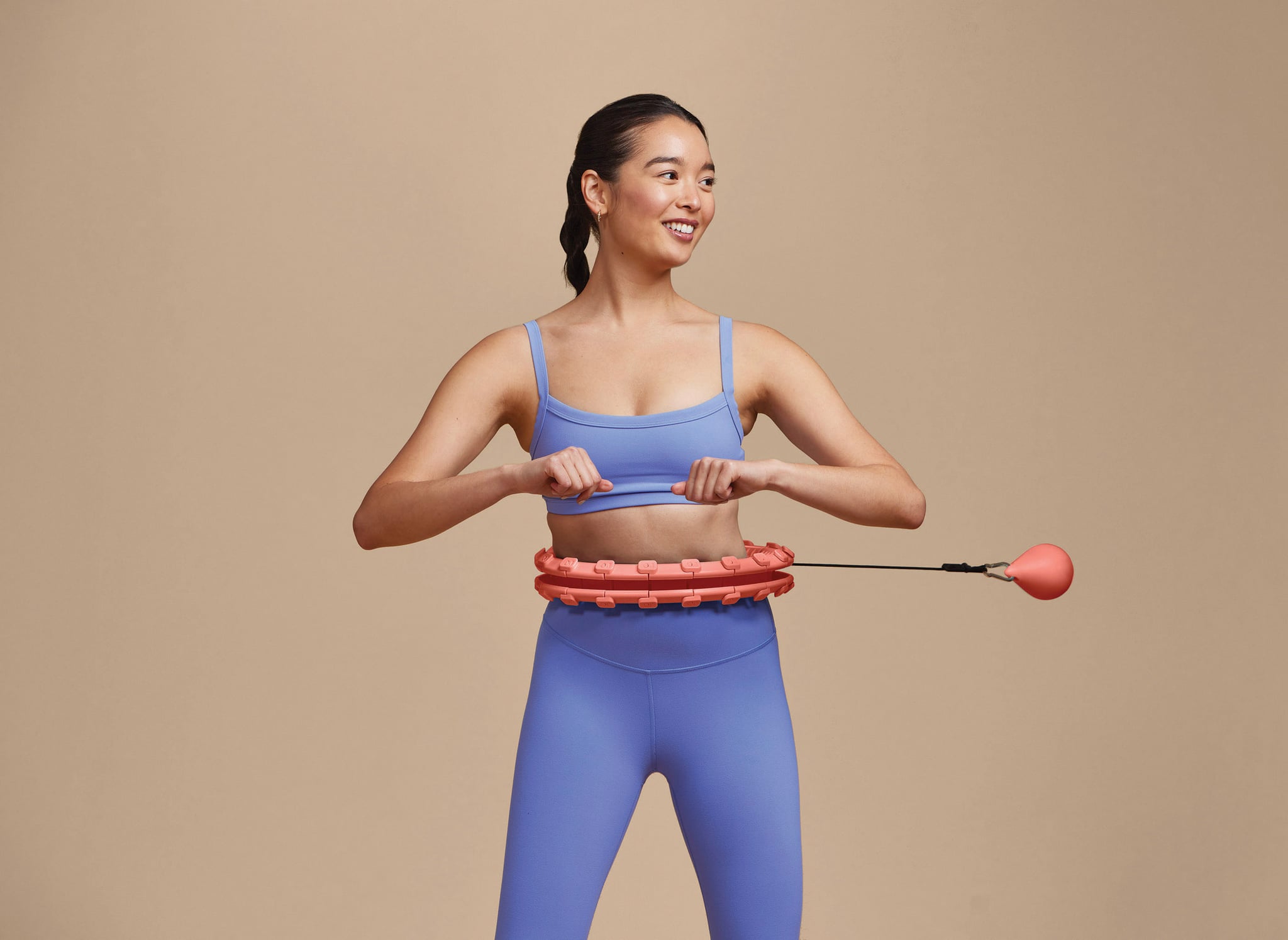 woman doing a weighted hula hoop workout - Photographer: Jason Innes