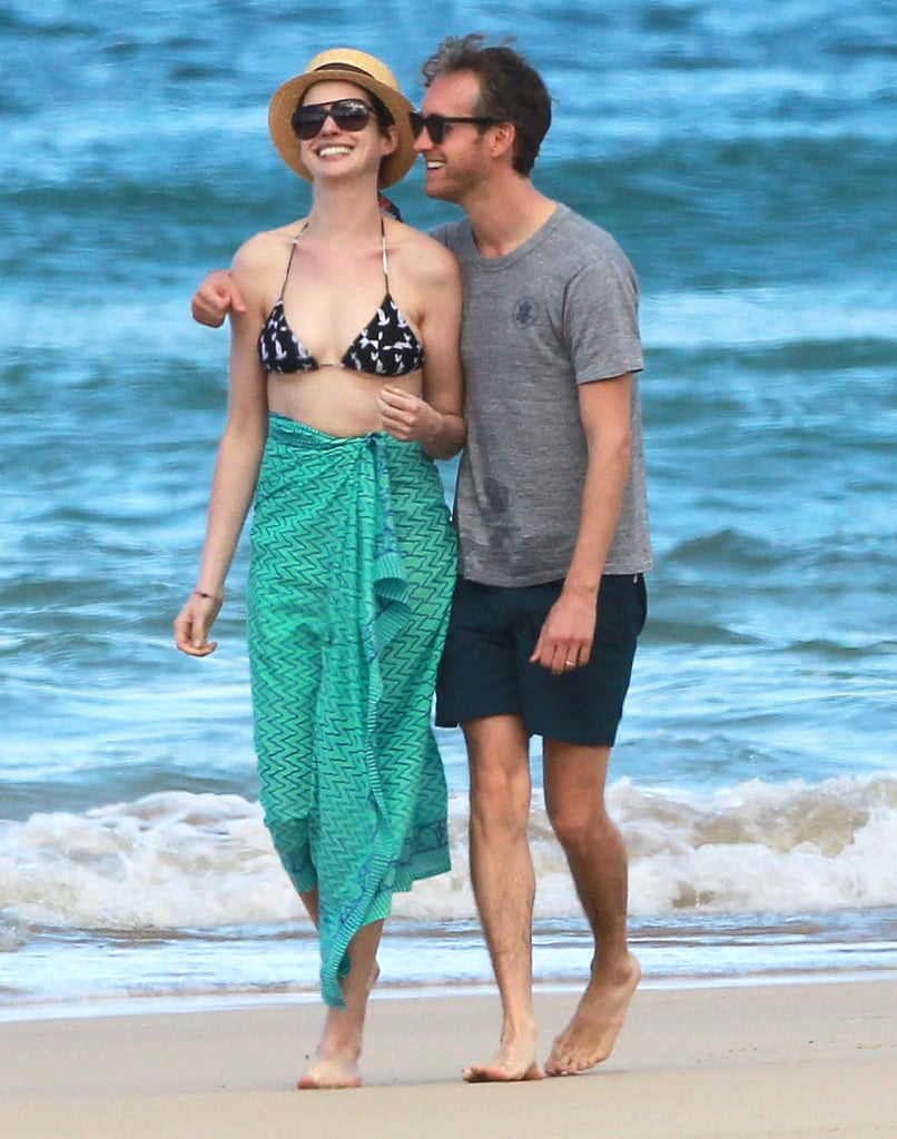 Anne Hathaway and Adam Shulman grinned as they strolled a beach in Oahu, HI.