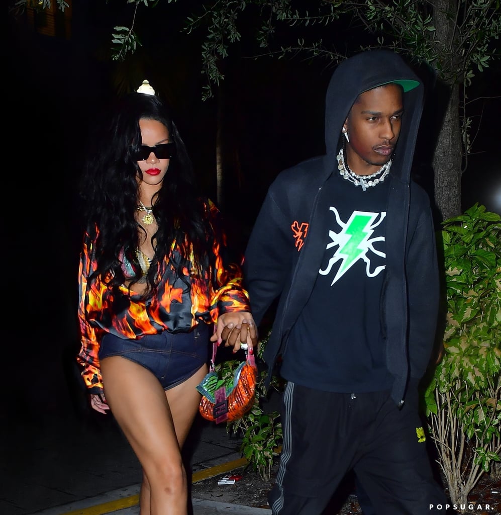 Rihanna's teeny denim shorts deserve to be declared an eighth wonder of the world. The singer and image entrepreneur recently stepped out in Miami with boyfriend A$AP Rocky while wearing the short-shorts that would even impress Daisy Duke. The beguiling bottoms in question are in fact Rihanna's own creation: Fenty sold them for $220, but they are sadly no longer available following the closure of the luxury brand earlier this year.
The rest of Rihanna's warm-weather outfit consisted of a silk flame-printed blouse by Vetements, which she wore over a striped lurex bikini top by Missoni. She accessorised with black Givenchy thong sandals, rectangular Attico x Linda Farrow sunglasses, and a vintage beaded Fendi baguette bag. Rihanna also wore her go-to necklace these days, a gold zodiac medallion by New York jeweller Briony Raymond, priced at $14,800. (She's a Pisces, by the way.)