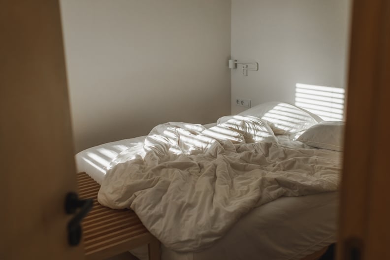 Photo of a Bed That Has Been Slept in With Outside Morning Lights Hitting It 