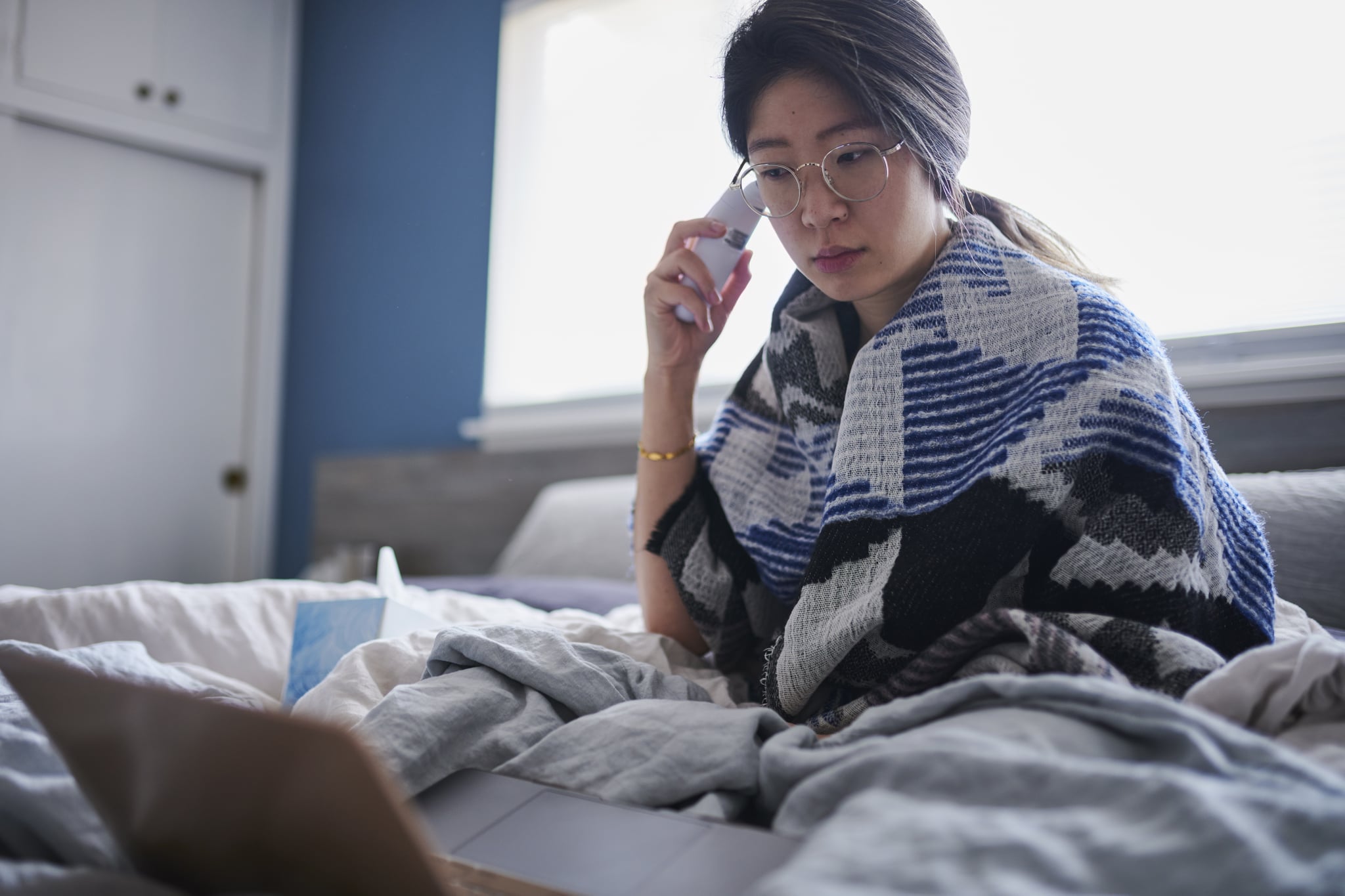 Woman taking fever in bed