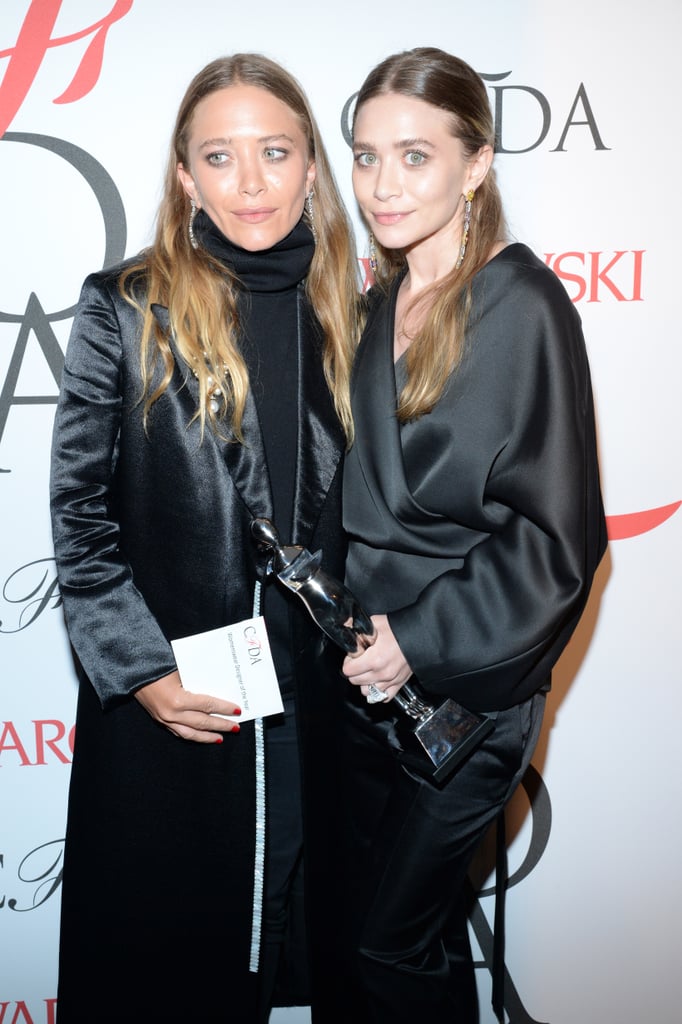 At the 2015 CFDA Fashion Awards, the twins post with their award both wearing center parts.