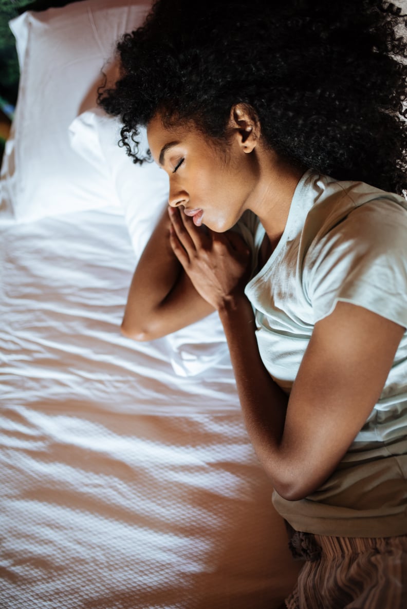 Beautiful black woman lying down in bed sleeping