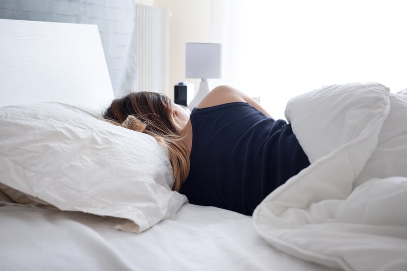 Back view of woman sleeping comfortable in bed