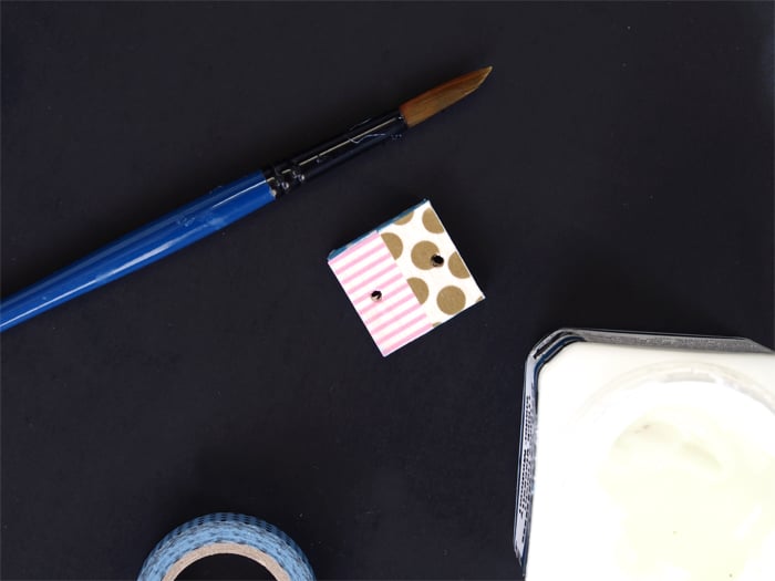 Once the varnish is dry, pop a ring through one hole and thread two strands of cord through the other. Fold the cord in half and secure with some washi around the middle to create a cute tassle! Now all this little guy needs is a few keys!