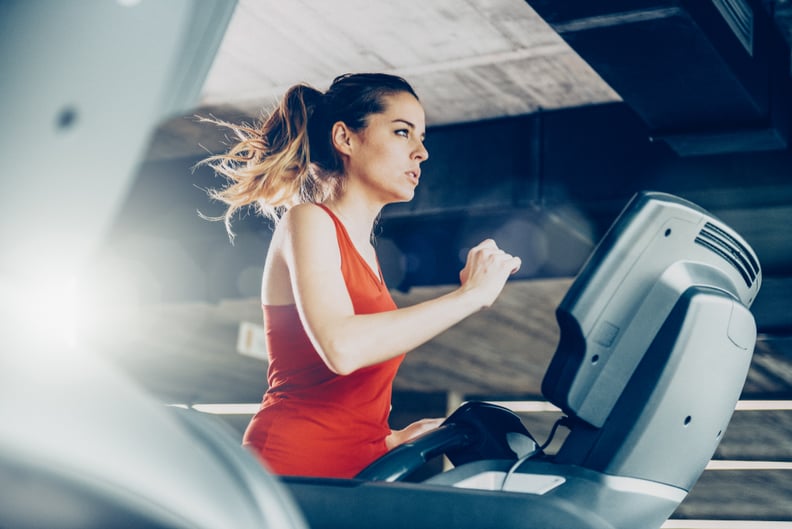 Healthy young woman in GYM running on treadmill