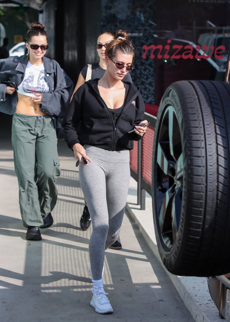 Addison Rae looks sporty in a white crop top and grey leggings while out  for some