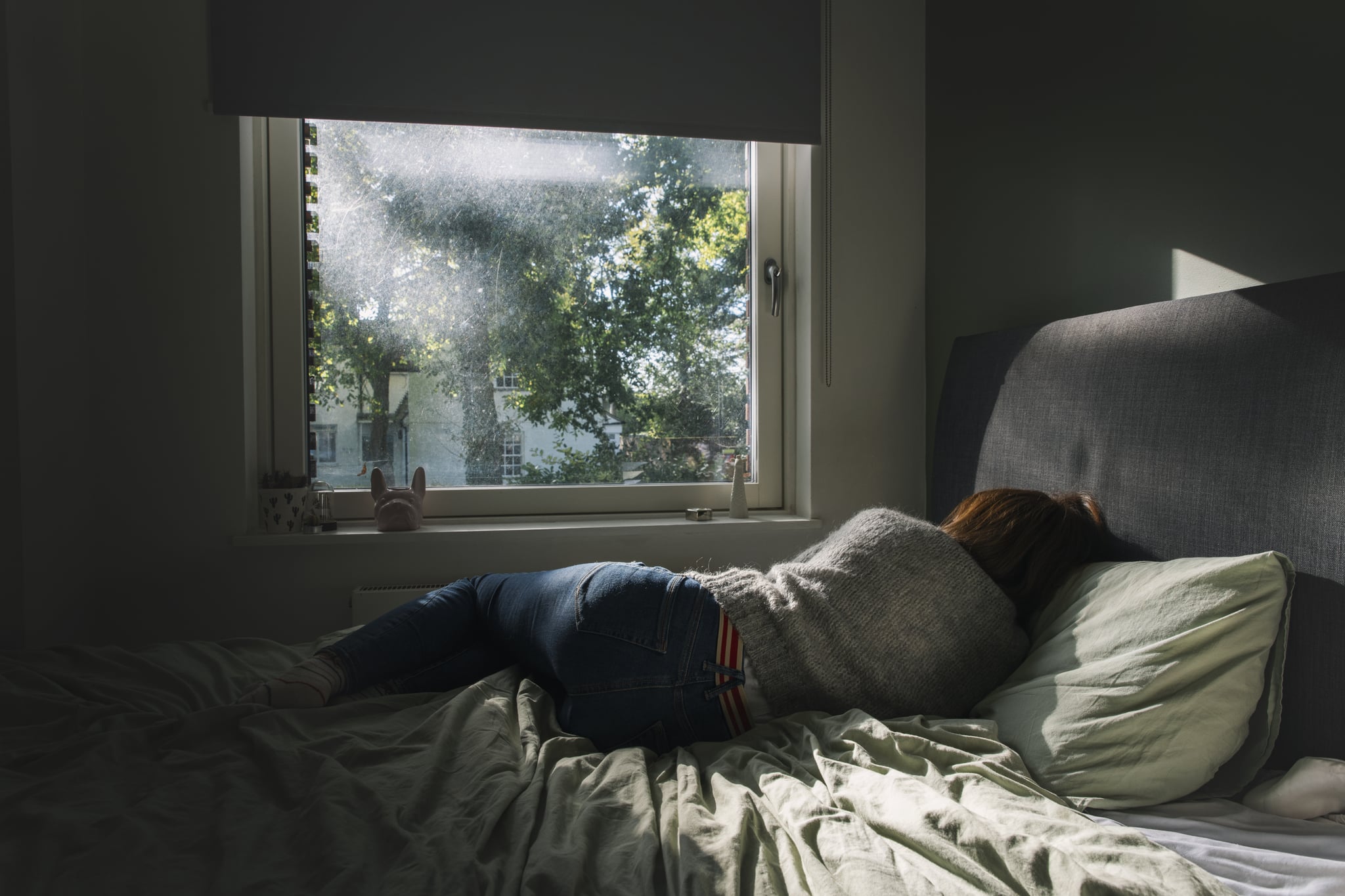 Woman feeling sad laying in bed.