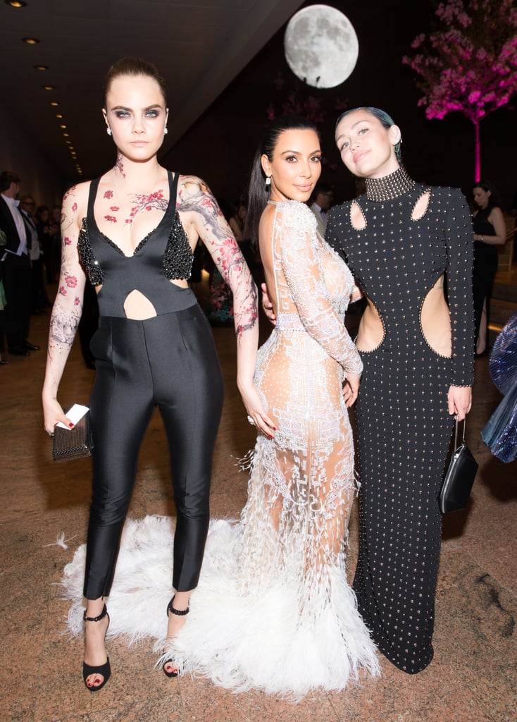 Cara Delevingne grabbed on to Kim Kardashian's famous rear while at the Met Gala cocktail reception with Miley Cyrus.