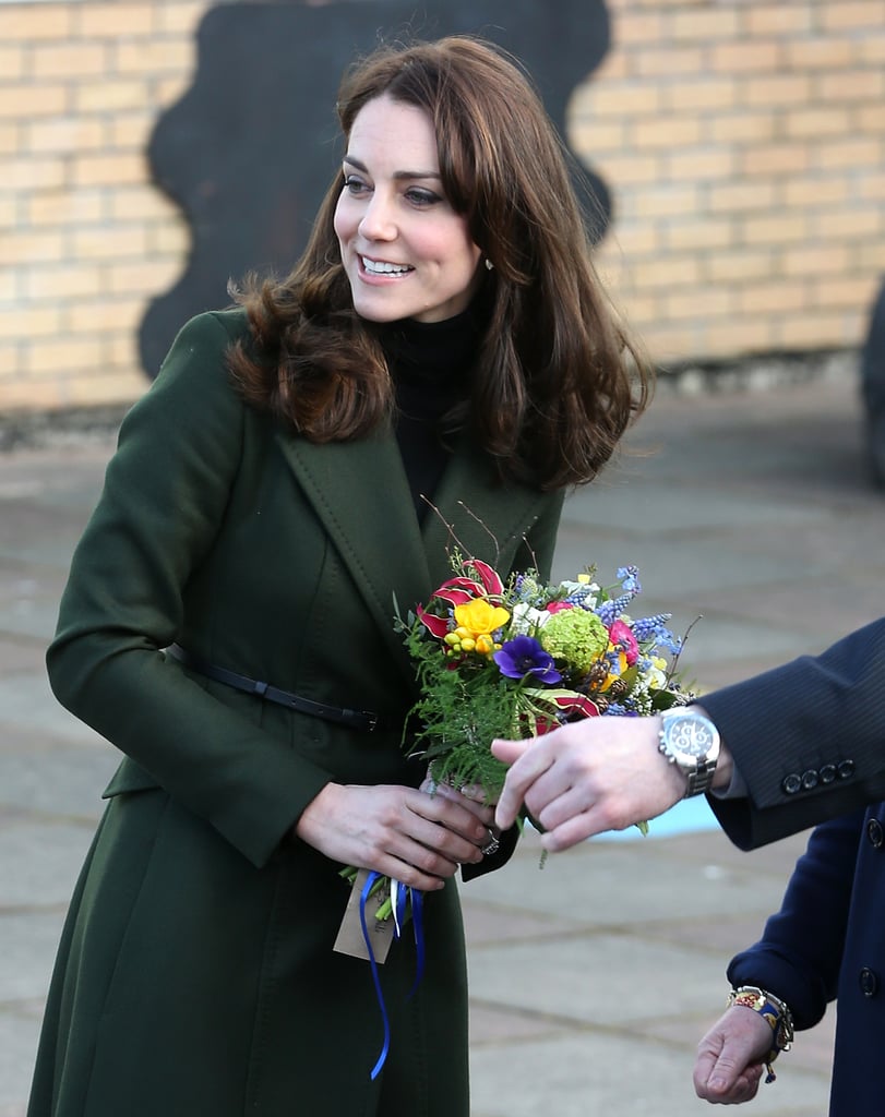 Her coat features a thin belt that cinches the structured design at the waist.