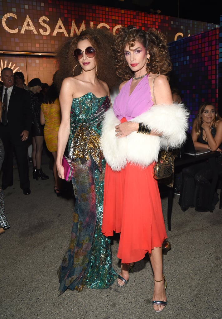 Amal Clooney pulled out all the stops with her retro, '70s-inspired Halloween costume this year. The 39-year-old human-rights lawyer, who welcomed twins Ella and Alexander in June, dressed up as a disco diva — big wig included — when she attended the Casamigos Halloween Party in West Hollywood on Friday night. Amal completed her disco look with glittery flared pants, a bustier top, and over sized sunglasses. Model Cindy Crawford also served major disco fever vibes with her similar costume. The two were spotted posing for photos throughout what appeared to be a fun night. Scroll through to see how Amal and Cindy channeled their inner disco divas ahead.