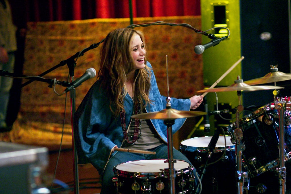 Remember when oversize capes were a thing? Roxy is a boho pro in hers while playing the drums.