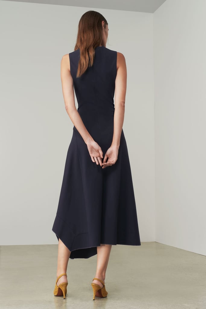 It also features a neat crew neck, as well as a delicately fitted bodice and draped asymmetric skirt.
