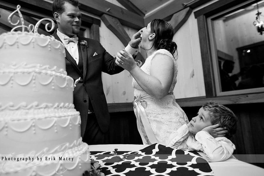 He watched with bated breath as the bride and groom wasted precious bites of cake all over each other's faces in a seemingly ridiculous adult ritual. Get it in your mouth, that's good cake!