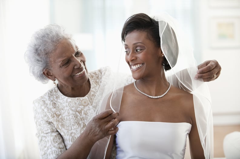 Grandmother helping granddaughter get ready on wedding