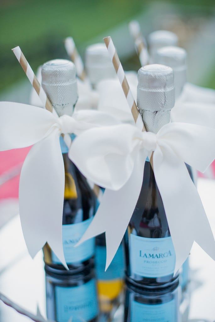 Give your guests a refreshment that's as tasty as it is adorable — ribbon-wrapped Champagne with gold straws. Give your guests a refreshment that's as tasty as it is adorable — ribbon-wrapped Champagne with gold straws.