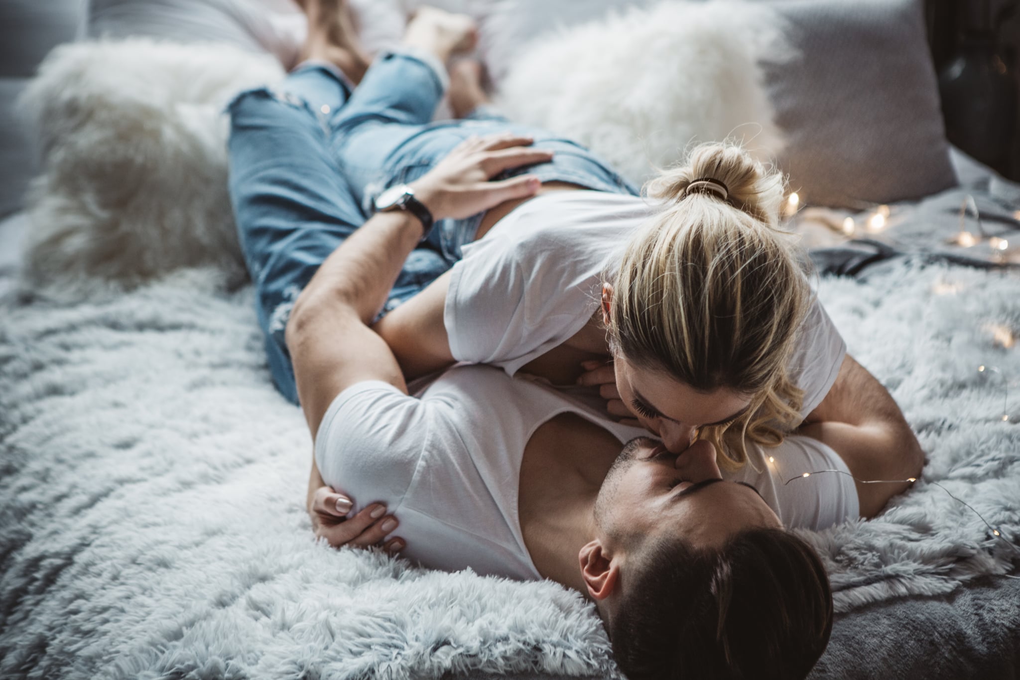 Couple on Valentine day enjoy in love. They are in bedroom, having romantic moment together embracing and kissing.