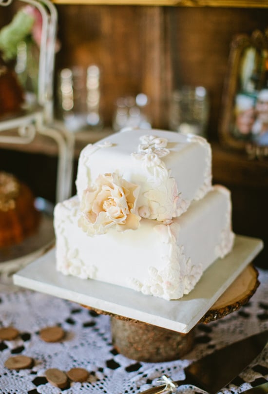 At only two layers high, this pretty white floral-covered cake makes a big impact. 
Photo by Sarah Layne Photography via 100 Layer Cake