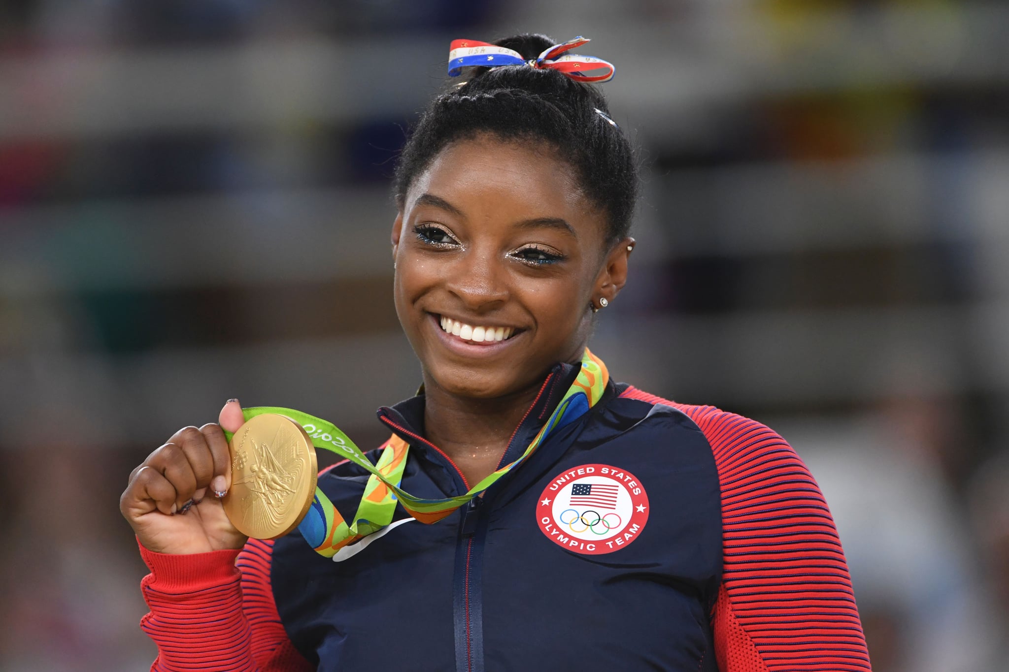 US gymnast Simone Biles celebrates on the podium of the women's floor event final of the Artistic Gymnastics at the Olympic Arena during the Rio 2016 Olympic Games in Rio de Janeiro on August 16, 2016. / AFP / Toshifumi KITAMURA (Photo credit should read TOSHIFUMI KITAMURA/AFP via Getty Images)